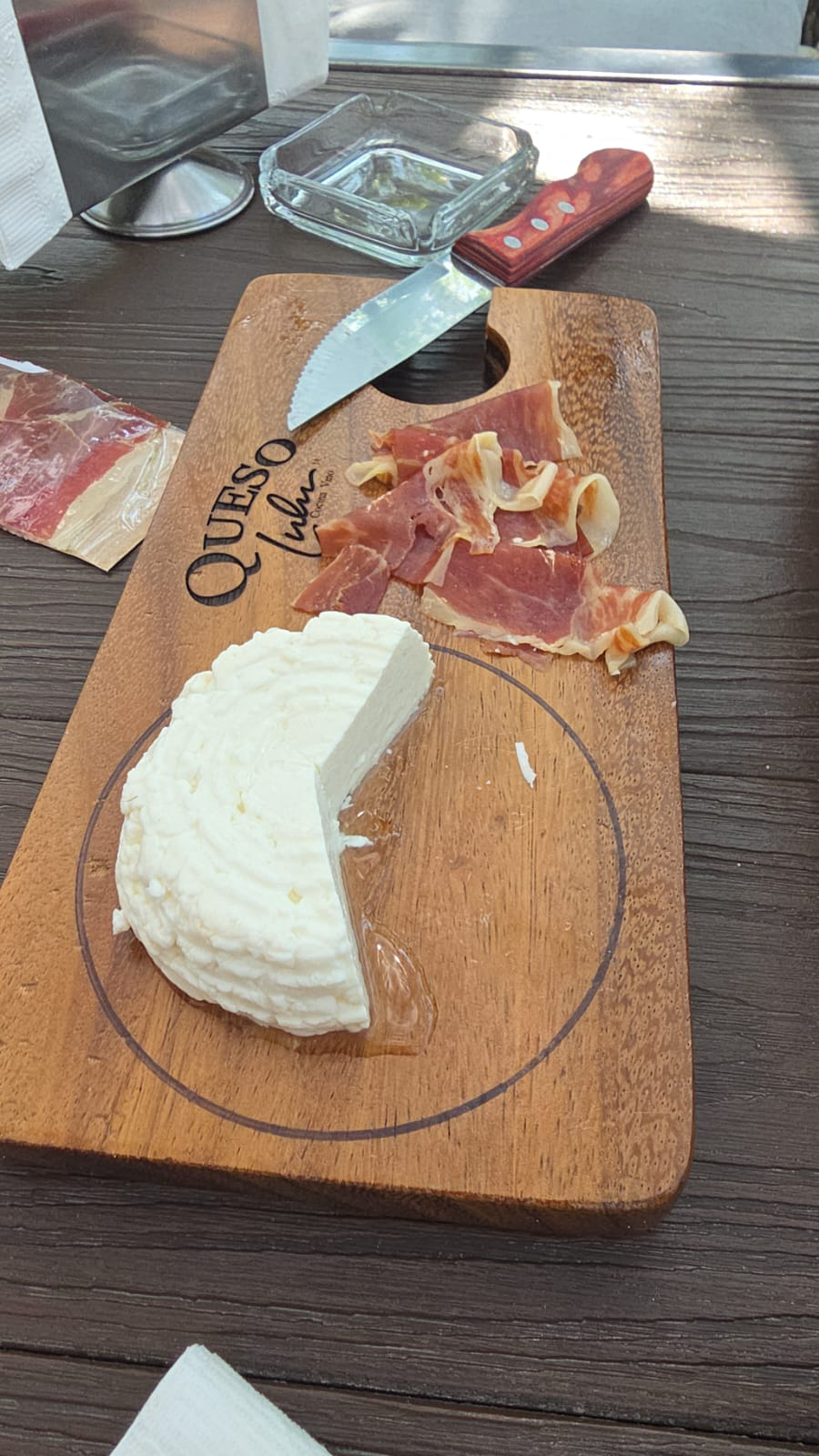 Queso panela acompañado con jamón serrano sobre una tabla